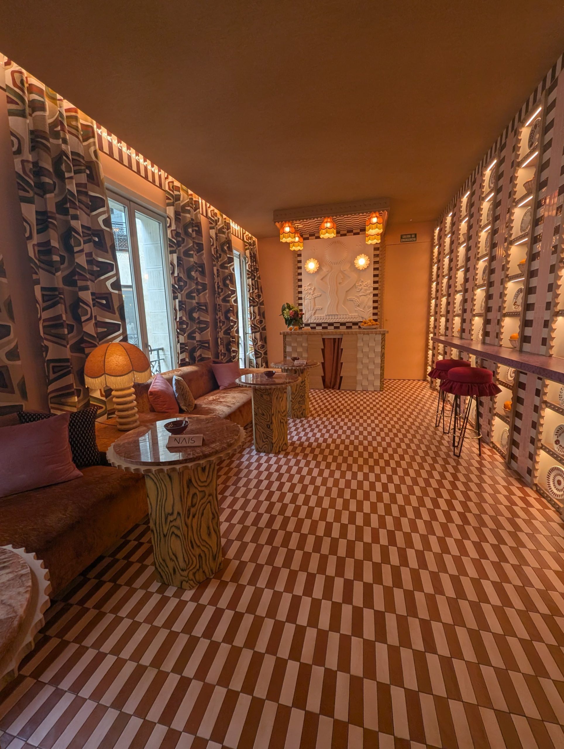 Sala de inspiración retro con suelos geométricos y decoración vintage en Casa Decor 2025